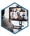 A group of managers and supervisors participating in a virtual workplace training workshop. The facilitator stands next to a screen sharing collaboration platforms and apps. The participants have laptops, tablets and smartphones.