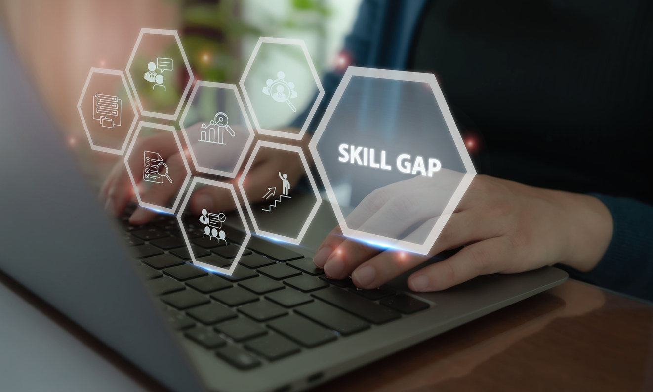 Person using a laptop with hexagonal graphics representing workforce assessment, employee development and a skill gap.